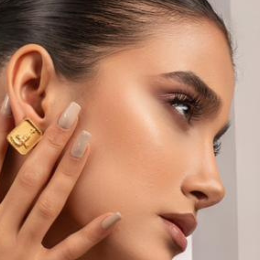 Woman wearing gold-plated Khanjer earrings in 925 sterling silver with Omani khanjar design