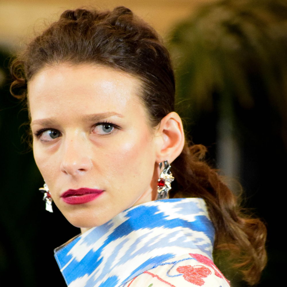 Woman wearing Victoria sterling silver earrings with deep red cubic zirconia garnet stones