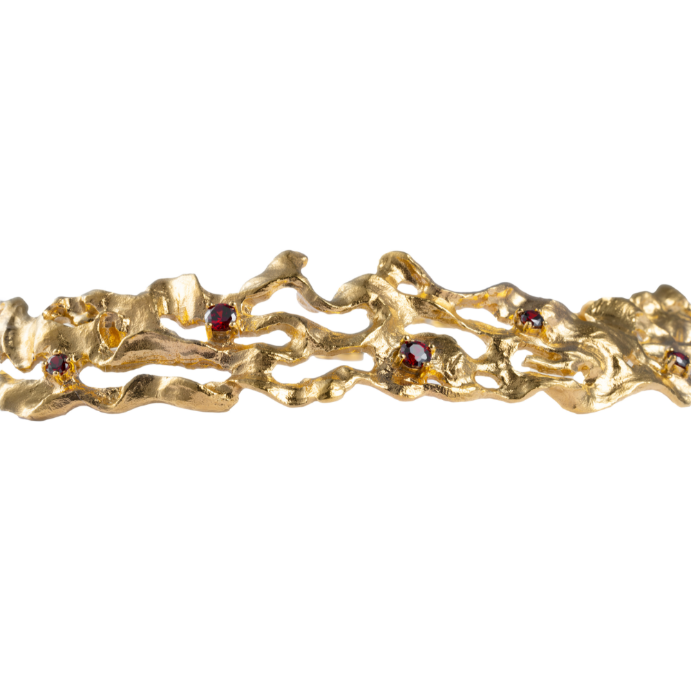 A gold-plated choker necklace with deep red cubic zirconia garnet gemstones.