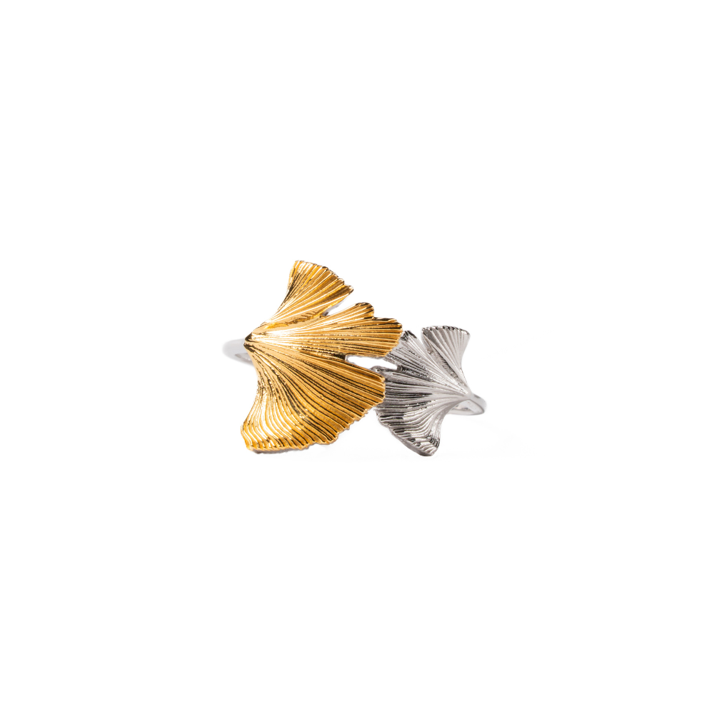 Gold and silver leaf-shaped ring on a white background