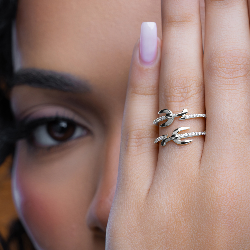 woman wearing a silver rhodium-plated band ring with cubic zirconia stones set in it.