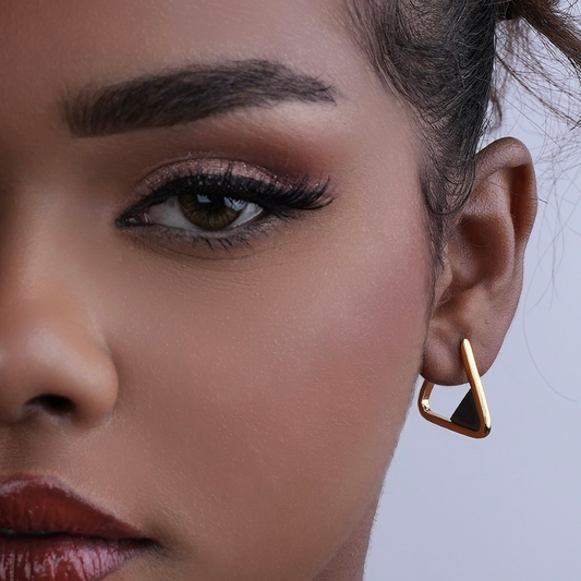 Woman wearing Scarlet gold-plated triangle hoop earrings with black hematite gemstone