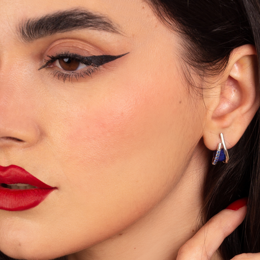 Woman wearing sterling silver Imara earrings with blue cubic zirconia stones and lapis lazuli gemstone