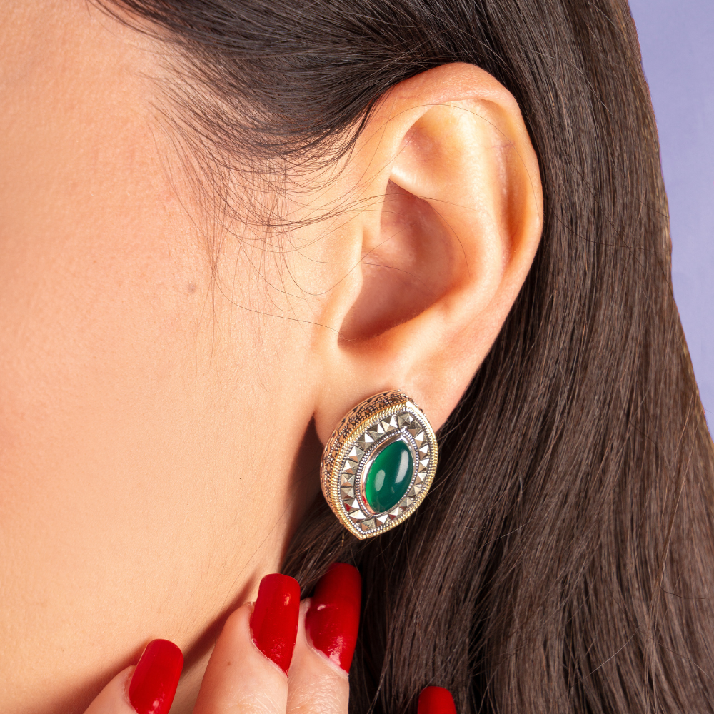 Woman wearing oxidized silver earrings with green agate stone, marcasite accents, and gold-plated rope detailing